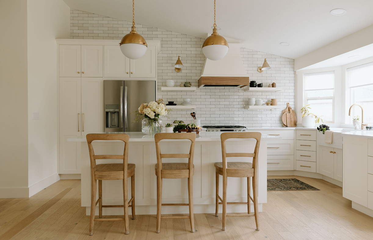 Modern kitchen with island and wooden chairs.