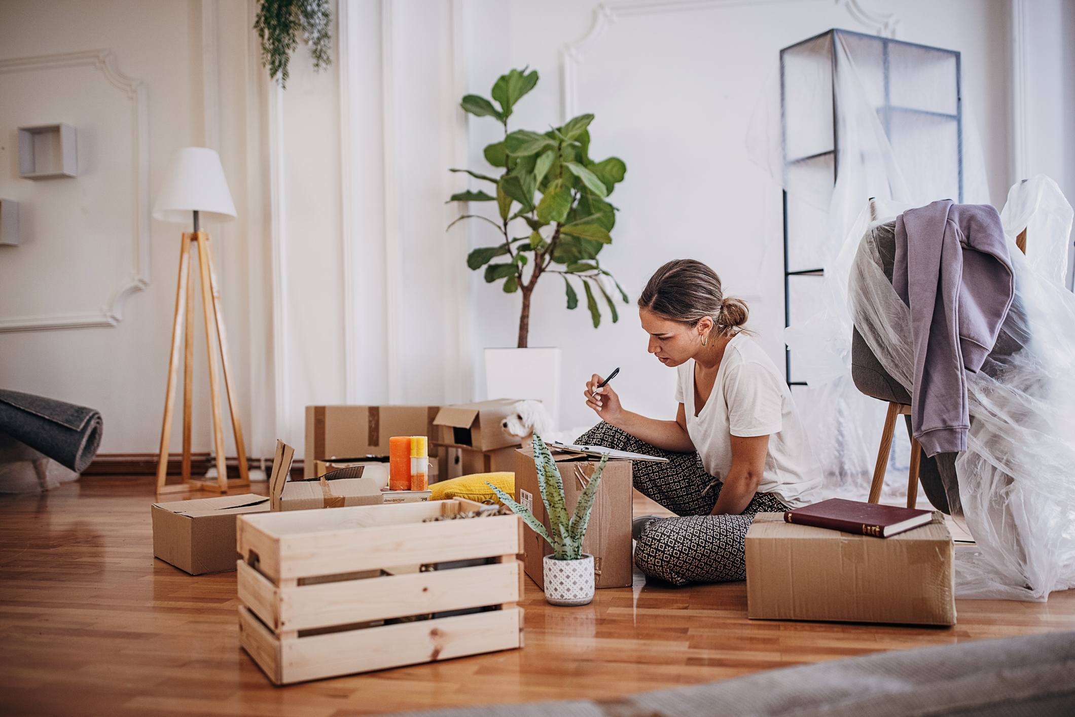 Woman organizing boxes in living room.