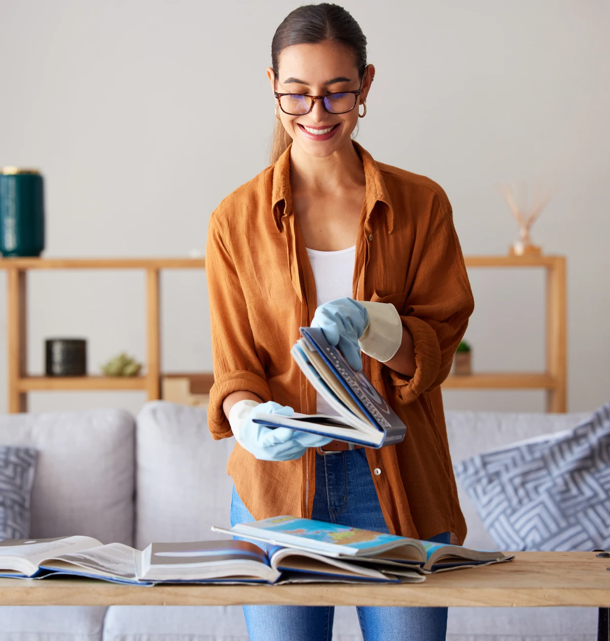 Woman flipping through books wearing gloves.