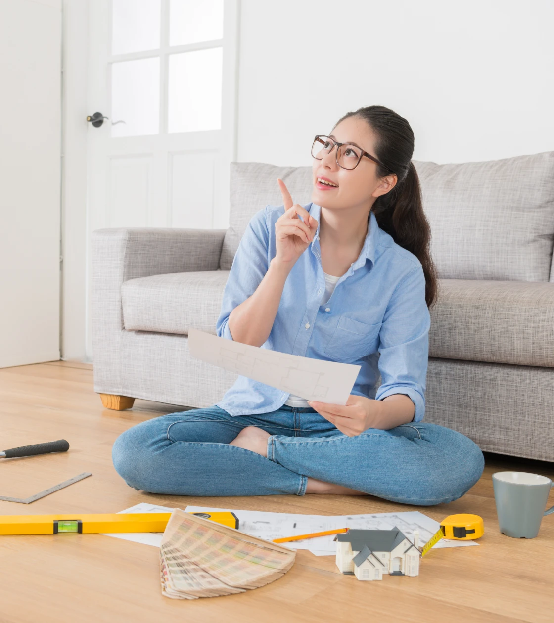 Woman planning home renovation sitting on floor.