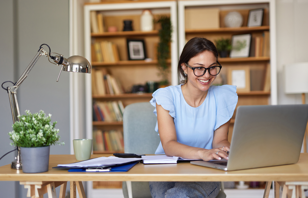 Smiling woman working on a laptop.