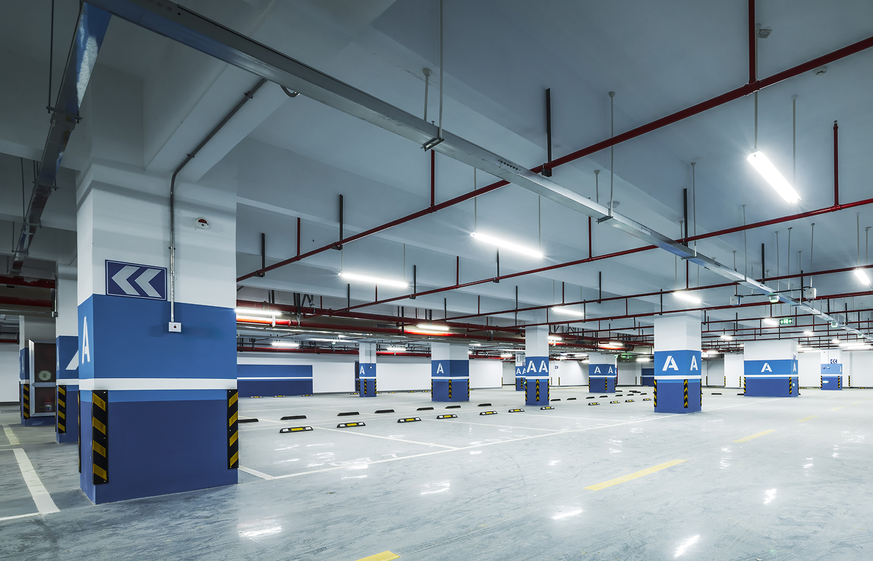 Empty underground parking garage with blue columns.